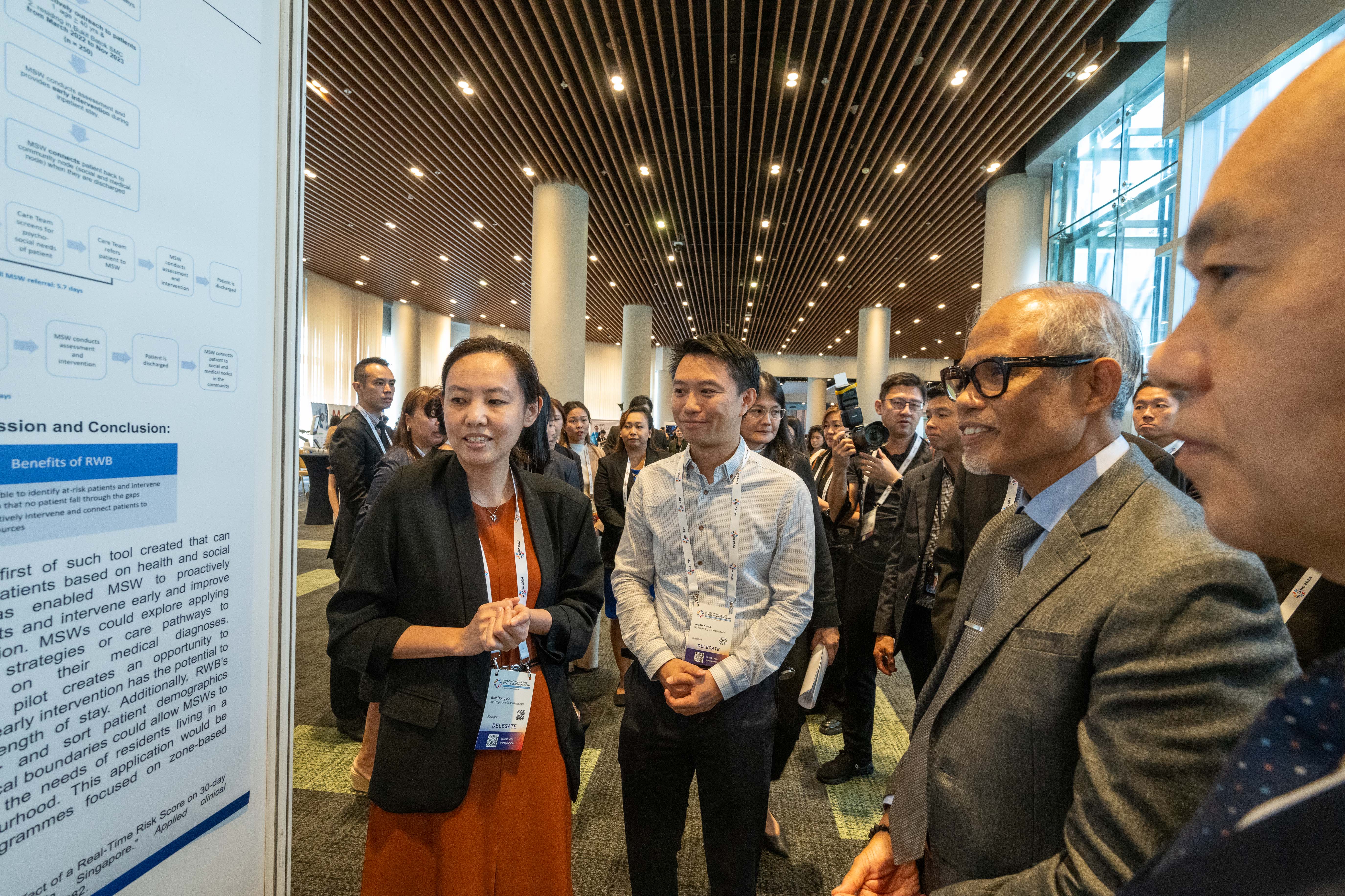 4.	Ms Ho Bee Hong, Senior Principal Medical Social Worker, NTFGH presents her poster to Second Minister for Health